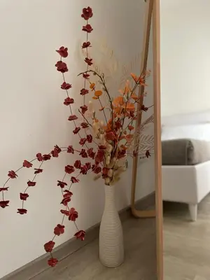 a white vase with flowers in a room at Cozy home close to the city center in Rome