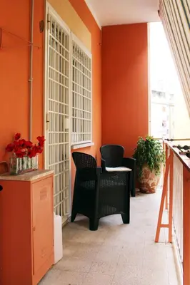 an orange room with two chairs and a table at Cozy home close to the city center in Rome