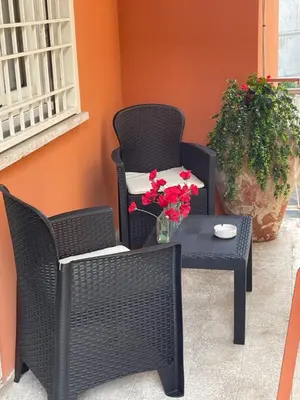 a patio with two chairs and a table with flowers at Cozy home close to the city center in Rome