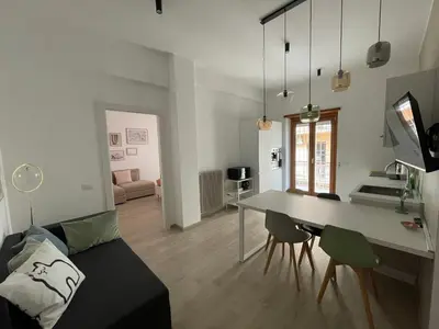 a kitchen and living room with a table and a couch at Cozy home close to the city center in Rome