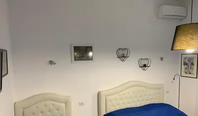 a bedroom with a bed with a blue blanket and a lamp at casa Nannarè in Rome