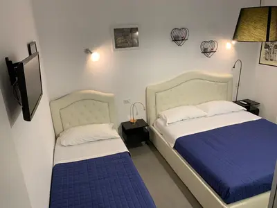 a bedroom with two beds with blue and white sheets at casa Nannarè in Rome