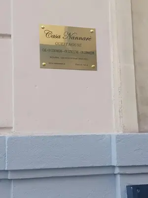 a sign for a guest house on a brick wall at casa Nannarè in Rome