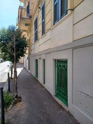 a building with a green gate on the side of a street at casa Nannarè in Rome