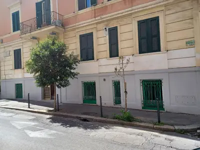 a building with green doors on a street at casa Nannarè in Rome