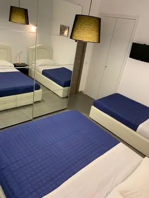 a room with two beds and a mirror at casa Nannarè in Rome