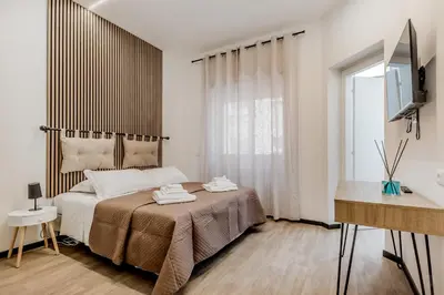a bedroom with a bed and a desk and a window at Casa Roma B&B in Rome