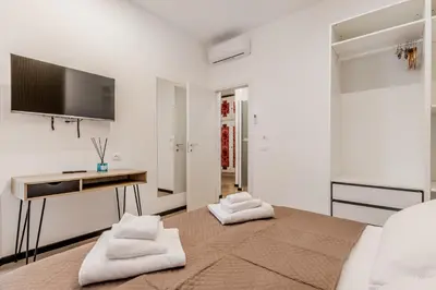 a white room with a bed and a desk at Casa Roma B&B in Rome