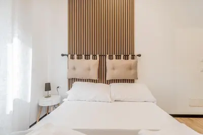 a bedroom with a white bed and a wooden headboard at Casa Roma B&B in Rome