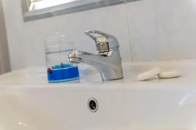 a bathroom sink with a faucet and a bottle of soap at Studio in Trastevere Village in Rome