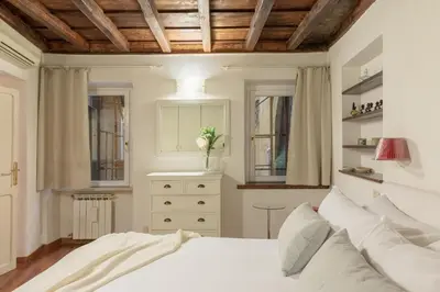 a bedroom with a white bed and two windows at iFlat Comfy Apartament in Campo de' Fiori in Rome