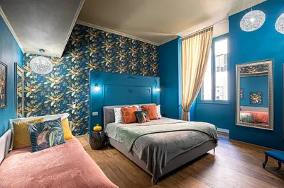 a bedroom with blue walls and a bed with orange pillows at Heritage Miracle Suite in Rome