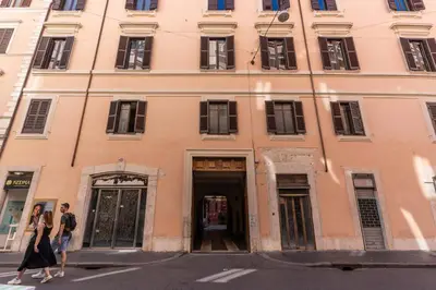 two people walking in front of a building at Heritage Miracle Suite in Rome