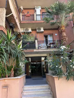 a building with stairs and palm trees in front of it at Magenta Terrione 2 in Rome