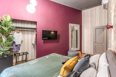 a bedroom with a purple wall and a couch at Corso Miracle Suite in Rome