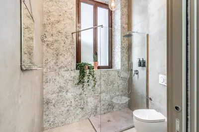 a bathroom with a glass shower with a toilet at Corso Miracle Suite in Rome