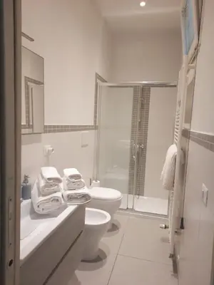 a white bathroom with a toilet and a shower at Le Scale di Roma in Rome