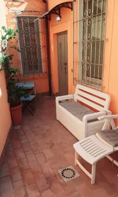 a patio with two white benches and a door at Le Scale di Roma in Rome