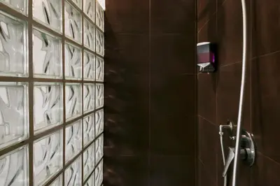 a bathroom with a shower with a tile wall at DM69 - Termini Monti Crossroads in Rome