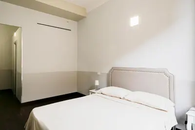 a bedroom with a white bed and a white wall at DM69 - Termini Monti Crossroads in Rome