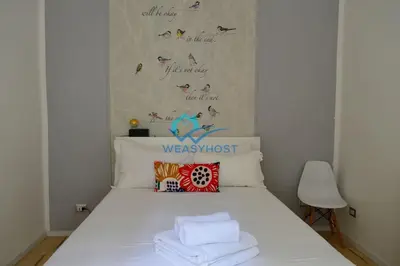 a white bed with towels on top of it at Pigneto Modern Apartment in Rome