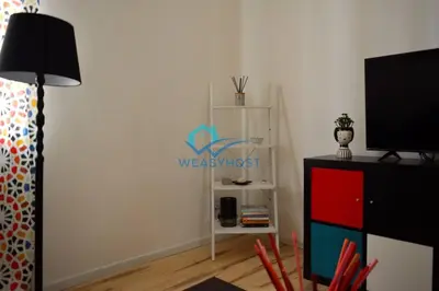 a living room with a television and a white shelf at Pigneto Modern Apartment in Rome