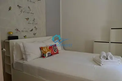 a white bed with towels and towels on it at Pigneto Modern Apartment in Rome