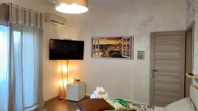 a living room with a flat screen tv on the wall at San Pietro Shabby Chic Apartment in Rome