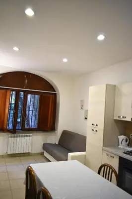 a small living room with a couch and a kitchen at ACasaMiaSanPietro in Rome