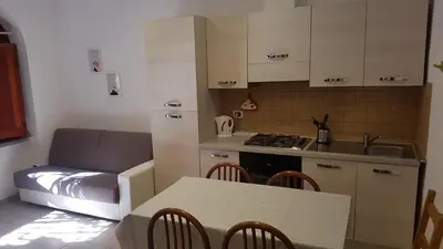 a kitchen with a table and a couch in a room at ACasaMiaSanPietro in Rome