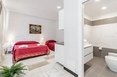 a bedroom with a red bed and a bathroom at BARONE HOUSE in Rome
