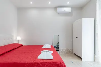 a small bedroom with a bed and a kitchen at BARONE HOUSE in Rome