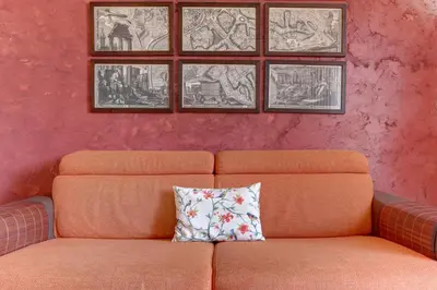 an orange couch with a pillow in a room at Colosseo Residenza Sette Sale in Rome