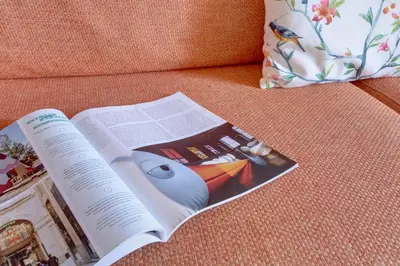 an open book on a couch with a pillow at Colosseo Residenza Sette Sale in Rome