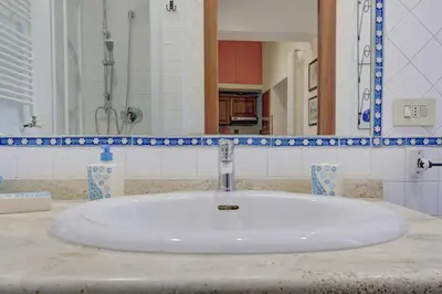 a white sink in a bathroom with a mirror at Colosseo Residenza Sette Sale in Rome