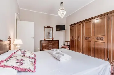 a bedroom with a large white bed with wooden cabinets at BBHOME History and design apartment in Testaccio district in Rome