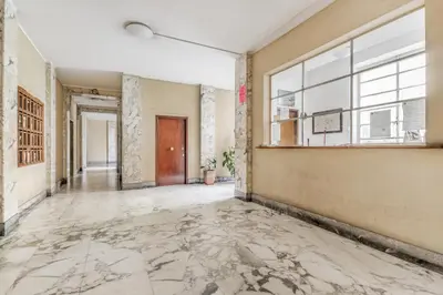 an empty hallway with a large window and marble floors at BBHOME History and design apartment in Testaccio district in Rome
