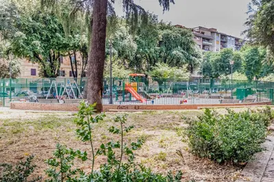 a playground in a park with a tree at BBHOME History and design apartment in Testaccio district in Rome