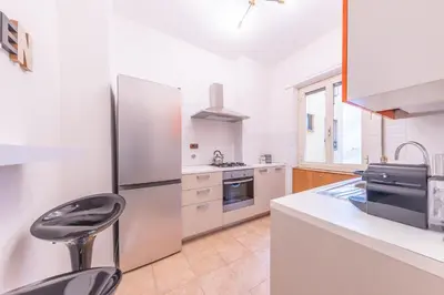 a kitchen with a stainless steel refrigerator and a stool at Lungotevere Apartment in Rome