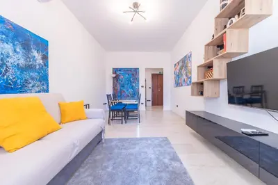 a living room with a white couch and yellow pillows at Lungotevere Apartment in Rome