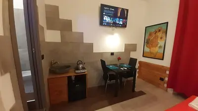 a small kitchen with a table and chairs in a room at HARMONY RELAX HYDROMASSAGE SAUNA AT THE VATICAN MUSEUMS in Rome