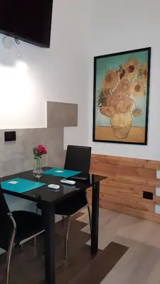 a dining room with a table and chairs and a painting at HARMONY RELAX HYDROMASSAGE SAUNA AT THE VATICAN MUSEUMS in Rome