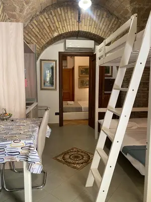 a room with a bunk bed and a table and a ladder at apartment vittorio Emanuele in Rome