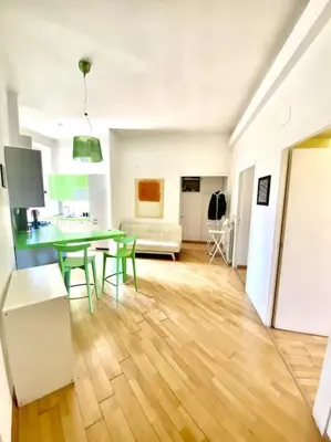 a living room with a table and a kitchen at Crisalide Apartment in Rome