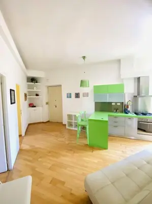 a kitchen with green and white cabinets and a table at Crisalide Apartment in Rome