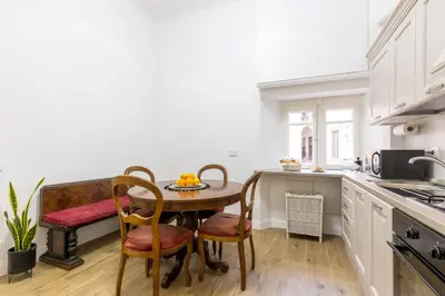 a kitchen with a table and chairs in a kitchen at Ottaviano Suites in Rome