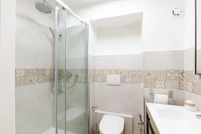 a bathroom with a shower and a toilet and a sink at Ottaviano Suites in Rome