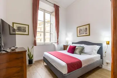 a bedroom with a large bed and a television at Ottaviano Suites in Rome