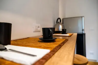 a wooden table with two black coffee cups on it at Appartamento Appio Latino in Rome
