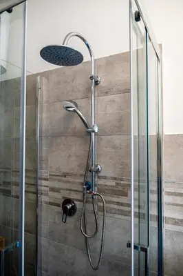 a shower with a glass door and a shower head at Appartamento Appio Latino in Rome